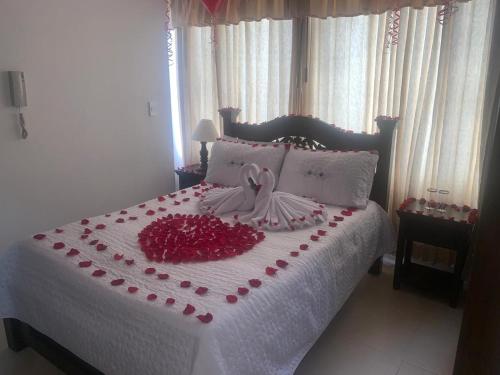 a bed with a bunch of red roses on it at Hotel Sipa in Duitama