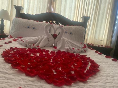 a bed with two swans and a bunch of roses at Hotel Sipa in Duitama