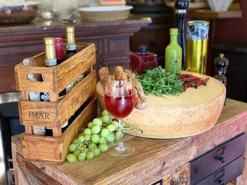 a table with a glass of wine and a bowl of grapes at Hotel Wegner - T h e culinary art hotel in Hannover