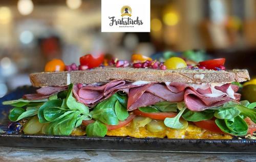 a sandwich with meat and vegetables on a plate at Hotel Wegner - T h e culinary art hotel in Hannover