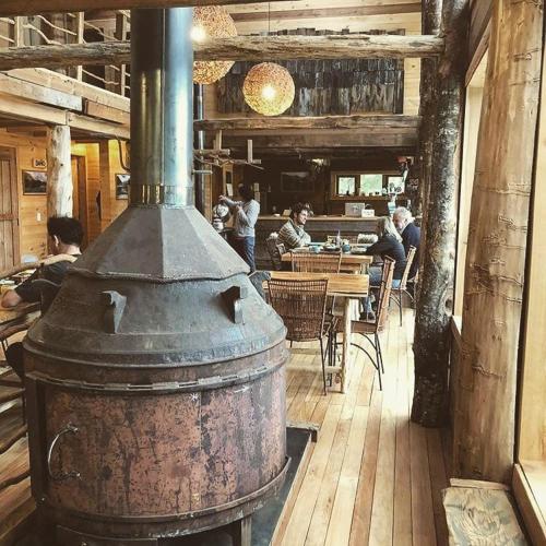 an old stove in a restaurant with people sitting at tables at Puelo Libre in Llanada Grande