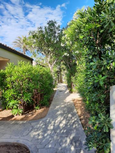 a walkway through a garden with trees and a building at La Perla di Sicilia in Marina di Modica