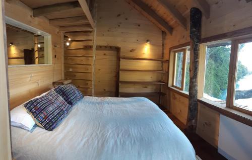 a bedroom in a log cabin with a bed at Puelo Libre in Llanada Grande