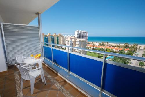 a balcony with a table and a view of the ocean at Hotel Tres Anclas in Gandía