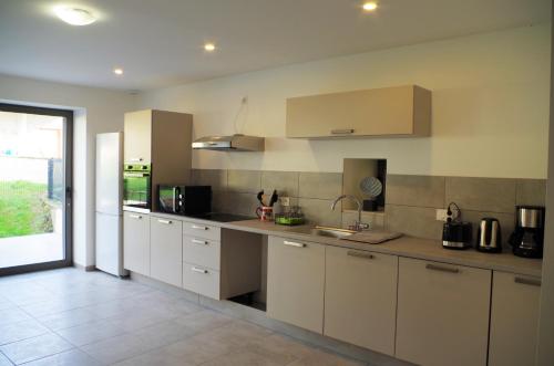 a kitchen with white cabinets and a counter top at Domaine Joseph Lafarge Wine Resort - Lady's House - La maison d'Henriette in Lugny