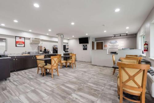 a restaurant with tables and chairs and a kitchen at Econo Lodge Inn & Suites in Mason City