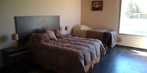 a bedroom with a bed and a couch in a room at Sol de las Sierras Zonda PREVIAJE in Zonda