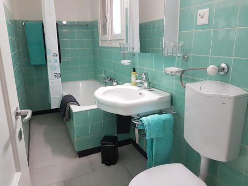 baño verde con aseo y lavamanos en Bed n Bureau Roggwil, en Roggwil