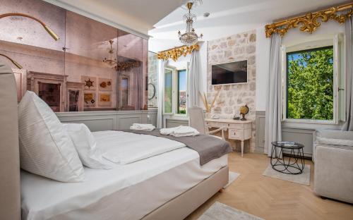 a bedroom with a large white bed and a desk at Heritage Villa Nobile in Dubrovnik