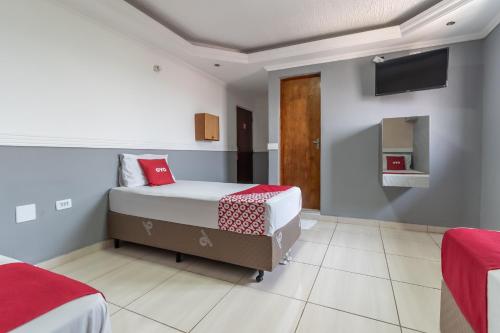 a bedroom with two beds and a tv on the wall at OYO Hotel San Remo, São Paulo in São Paulo