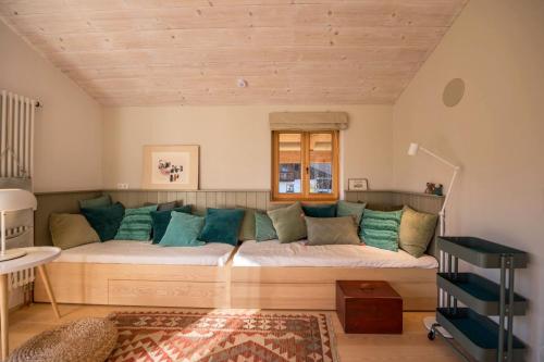 a living room with a large couch with blue pillows at Ferienwohnung Bei der Töpferei in Pittenhart