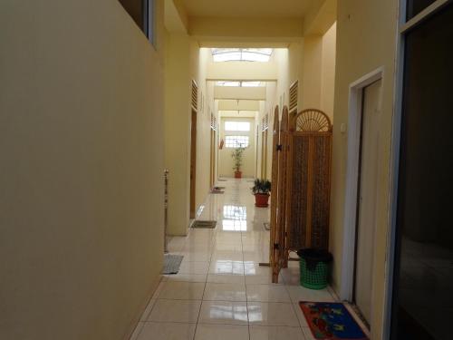 a hallway with a long hallway with a tile floor at Hotel Musafir Inn in Padang