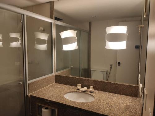 a bathroom with a sink and a mirror at Flat Plaza Hotel - Setor de Hotéis Norte in Brasília