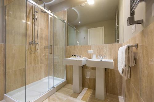 a bathroom with two sinks and a shower at Suite della Pigna in Rome