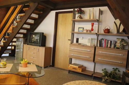 a living room with a book shelf and a staircase at Ferienhaus Kornblume in Ronshausen