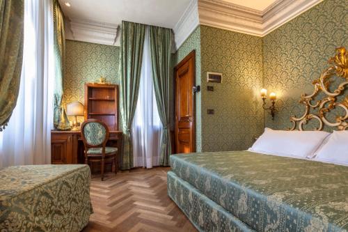 sypialnia z łóżkiem, biurkiem i krzesłem w obiekcie Palazzina Veneziana w Wenecji