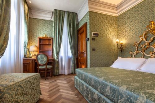 a bedroom with a bed and a desk and a chair at Palazzina Veneziana in Venice