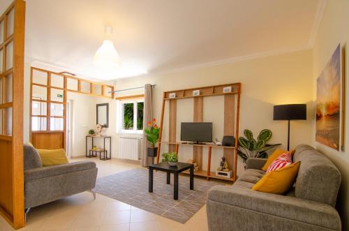 a living room with two couches and a tv at Baleal Sunset Residence in Baleal