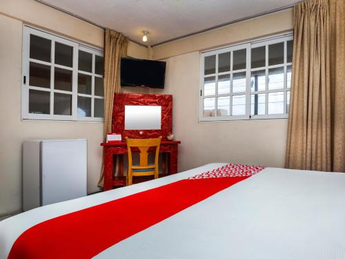 um quarto com uma cama branca e um cobertor vermelho em Hotel D Gomar em Isla Mujeres