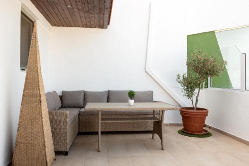 a patio with a couch and a table at Terinikos Sunny Garden Hotel & Junior Suites New Renovation 2025 in Ialyssos