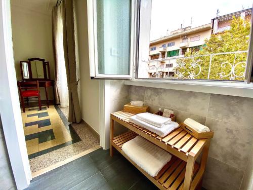 Zimmer mit einem Fenster und einer Bank mit Handtüchern in der Unterkunft Domus Delphi in Rom