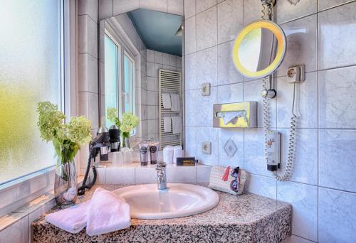 a bathroom with a sink and a mirror at Wessinger in Neu Isenburg
