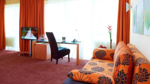 a hotel room with a couch and a desk with a computer at Wessinger in Neu Isenburg