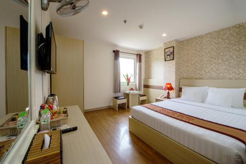Habitación de hotel con cama y TV en Palago Park View Hotel, en Ho Chi Minh