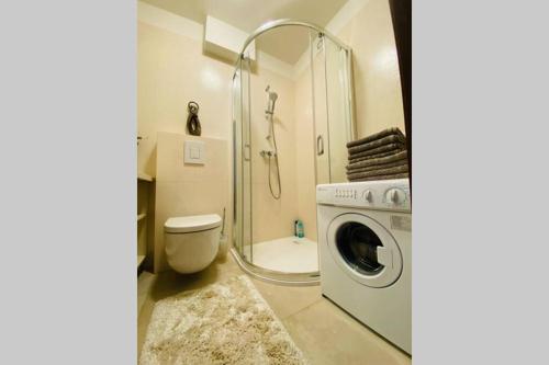 a bathroom with a shower toilet and a washing machine at Apartament Stylowy Pruszków Centrum in Pruszków