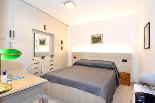 Bellagio Pescallo Guesthouse في بيلاجيو: غرفة نوم صغيرة مع سرير ومكتب