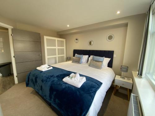 a bedroom with a large bed with two towels at Marie’s Serviced Apartment 1 Bed CityStay, parking in Bedford