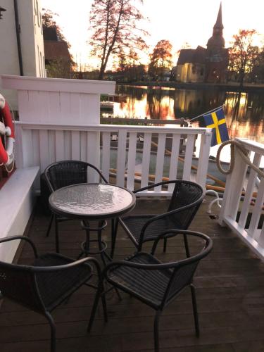 een tafel en stoelen op een balkon met een rivier bij Stugan med Bryggan i Gamla Staden in Eskilstuna