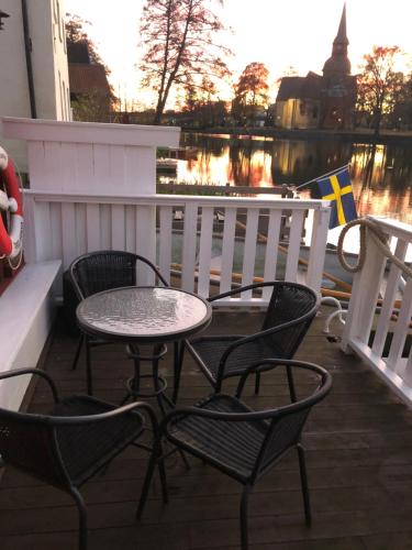 a table and chairs on a balcony with a river at Stugan med Bryggan i Gamla Staden in Eskilstuna