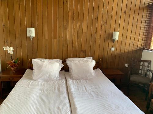 1 cama con sábanas blancas y almohadas en una habitación en Katarino Mountain House en Razlog