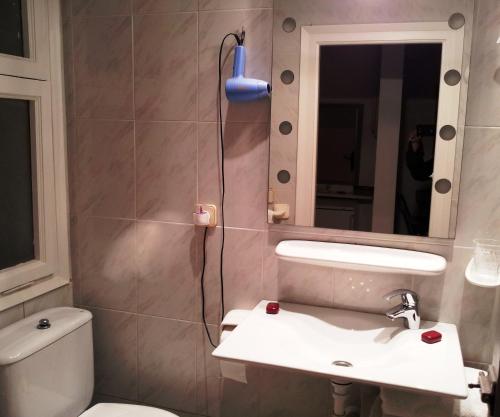 a bathroom with a toilet and a sink and a mirror at Apartaments Mare Nostrum in Sitges
