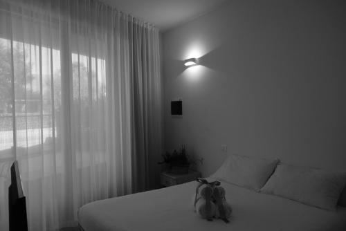 two stuffed animals sitting on a bed in a bedroom at Villa Alcova in Caorle