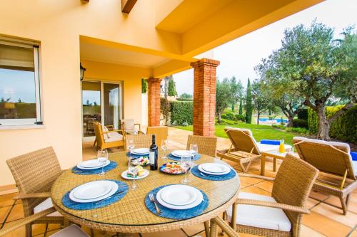 a dining room with a table and chairs on a patio at Monte Rei Golf & Country Club in Vila Nova de Cacela