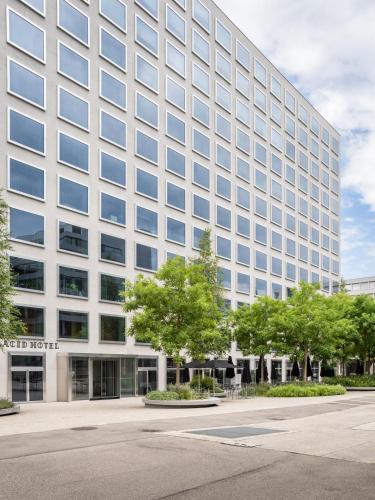 a tall white building with trees in front of it at Placid Hotel Design & Lifestyle Zurich in Zürich