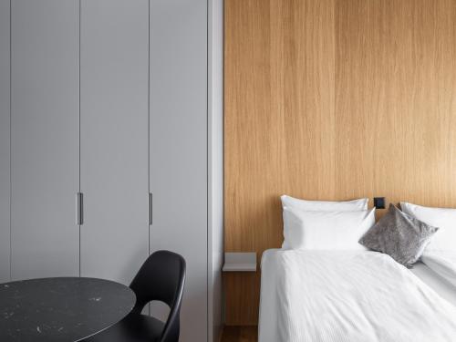 a bedroom with two beds and a table and a table and chair at Placid Hotel Design & Lifestyle Zurich in Zürich