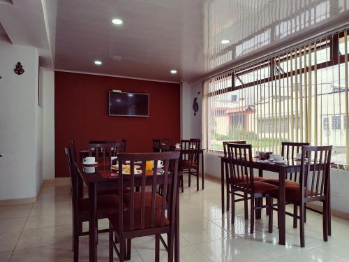 a dining room with tables and chairs and a tv at Hotel Confort Bogota in Bogotá