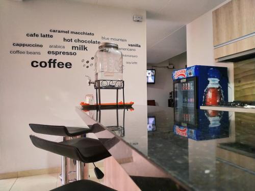 a bar with stools and a drink bottle on a counter at Hotel Confort Bogota in Bogotá