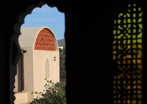 a small church with a red roof and a window at Nomada hotel in La Ventana
