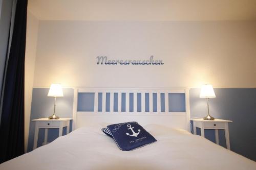 キュールングスボルンにあるStrandschloesschen-Haus-I-WE-13-9890のベッドルーム1室(青い枕付きのベッド1台付)