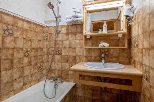 a bathroom with a sink and a tub and a shower at Hôtel Les Côtes, Résidence Loisirs et Chalets in Morzine