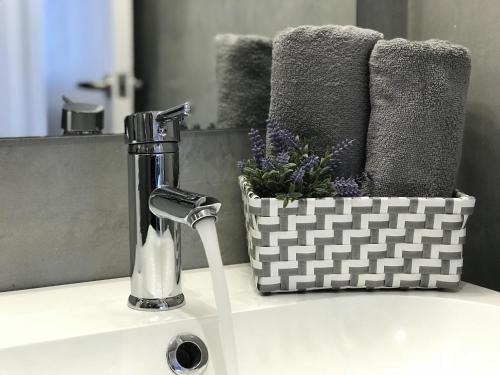 a bathroom sink with a faucet and a basket of flowers at Lets holidays apartment in Sant Martí in Barcelona