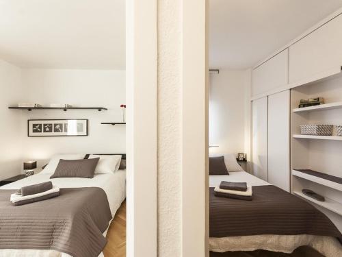 Lets holidays apartment in Sant Martí في برشلونة: سريرين في غرفة نوم بجدران بيضاء
