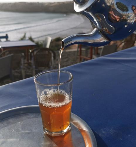 a drink is being poured into a glass on a table at Tigmi Blue - Imsouane Surf et Océan in Imsouane