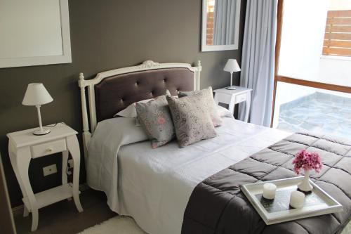 ein Schlafzimmer mit einem Bett und einem Tisch mit Blumen darauf in der Unterkunft FANCY HOME in San Carlos de Bariloche