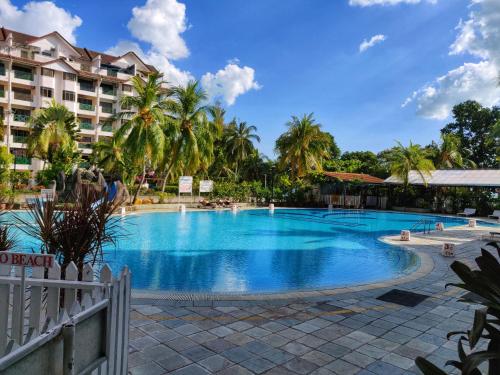 basen w ośrodku z palmami w obiekcie Wan's Apartment Bayu Beach Resort w mieście Kampong Si Rusa