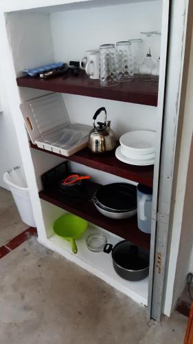 a kitchen shelf with plates and pans and a tea kettle at Togo B&B Farallon in Playa Blanca